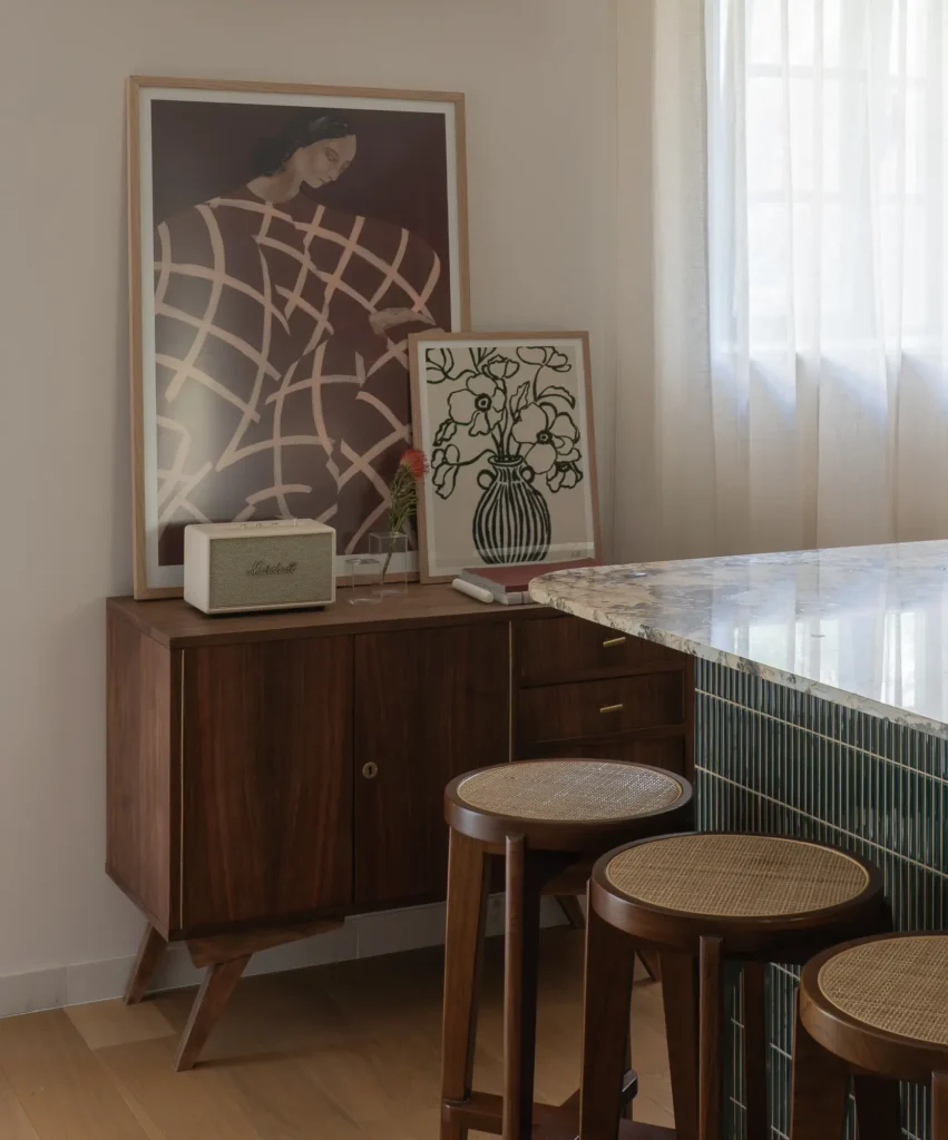 Comodă vintage recondiționată cu artă și obiecte personale, exemplu de curatoriere într-un apartament cu elemente retro