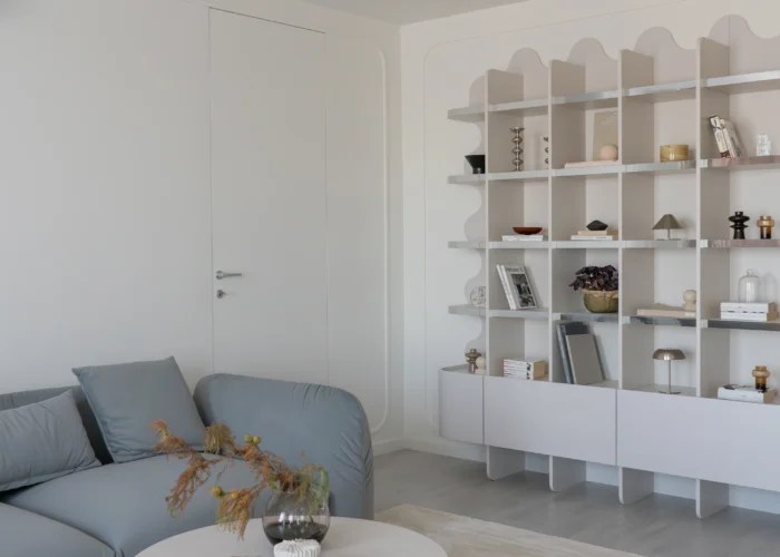 design interior living cu biblioteca inedita cu contur ondulat si cant de tip oglinda si canapea Mille bleu teal