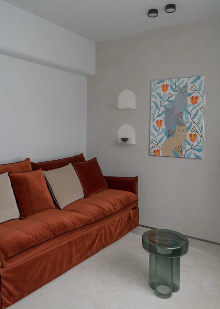 Birou acasă cu canapea cărămizie, măsuță din sticlă verde și artă colorată, rezultat al unui moodboard de design interior personalizat