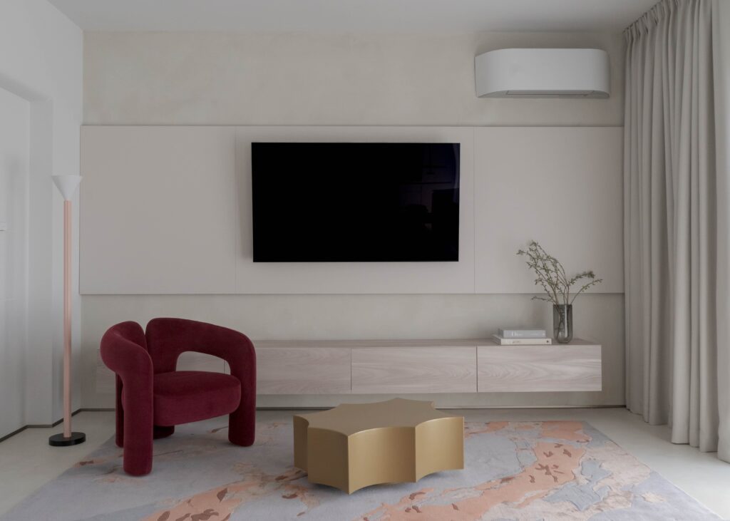 Sourcing în design interior: fotoliu burgundy de designer și măsuță sculpturală metalică, piese ready-to-buy
